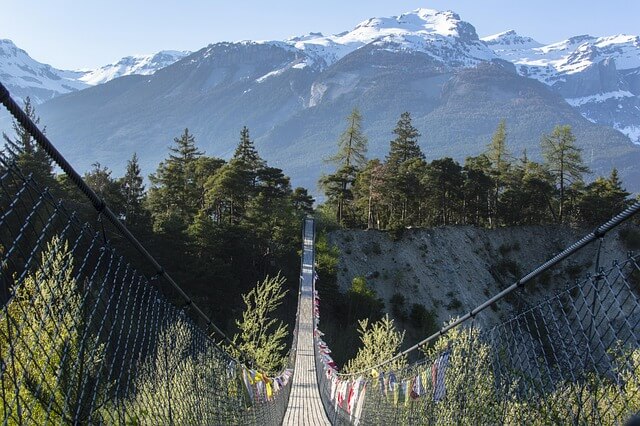 Long suspension bridge in Bhutan crossing a river with mountain view
